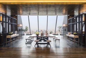 Un comedor moderno con techo alto, ventanas amplias y vistas a la ciudad.