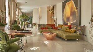 Uma sala de estar moderna com um sofá verde, uma mesa de centro de madeira e uma área de jantar com mesa e cadeiras.