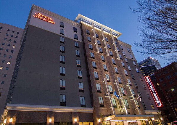 A multi-story hotel with a prominent sign for Hampton Inn & Suites.