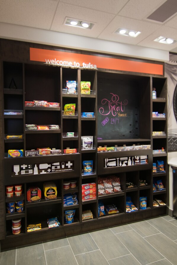 A snack display with various packaged foods and a chalkboard sign that reads "Treat Yourself."