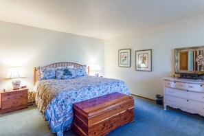 A bedroom with a wooden bed, two bedside tables, a dresser, and a mirror.