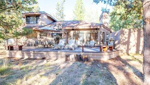 Una casa moderna con un patio amueblado al aire libre y una barbacoa.