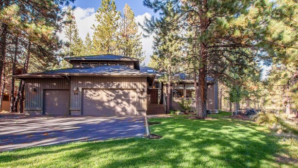 A two-story house with a garage, surrounded by tall pine trees. - Cypress 10 (Bend)