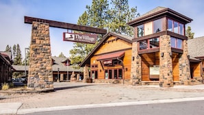 En stuga med en entré av sten, en träfasad och en skylt med texten ”The Village at Sunriver”.