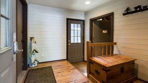A wooden interior with a door, a bench, and a chest of drawers. - Diamond Peak 23 (Bend)