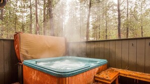 A hot tub in a forested area with wooden decking and steps. - East Butte 10 (Bend)