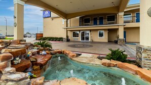 Un hôtel doté d’un espace piscine agrémenté de formations rocheuses et d’une fontaine.