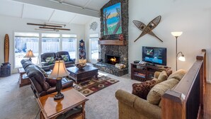 Uma sala de estar aconchegante com lareira, assentos confortáveis e uma televisão.