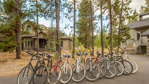 A row of bicycles parked in front of a building with a porch and a staircase leading to the entrance. - Splitrock 11 (Bend)