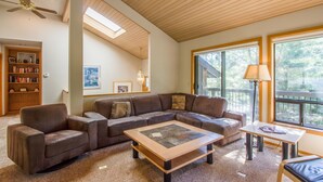 A spacious living room with a sectional sofa, a coffee table, and a bookshelf. - Sumac 9 (Bend)
