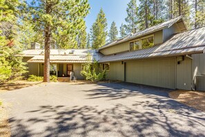 A two-story house with a covered driveway and a front porch. - Tan Oak 29 (Bend)