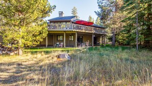 A two-story house with a balcony, surrounded by trees and a grassy area. - Tan Oak 15 (Bend)