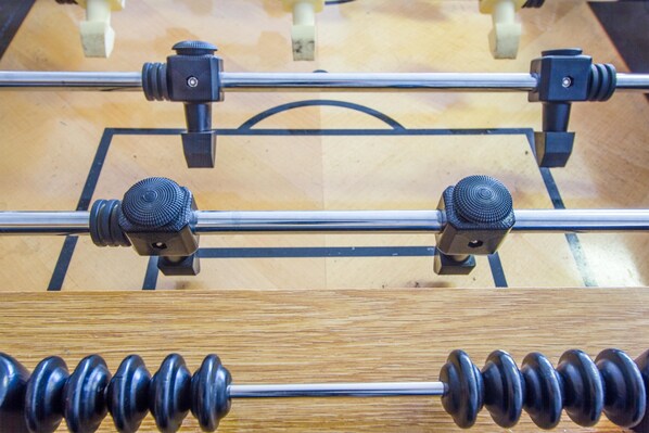 A close-up of a wooden table with metal rods and black knobs, likely part of a piece of furniture.