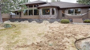 A modern house with a stone facade, large windows, and a well-maintained lawn. - Vista 16 (Bend)