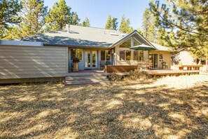Ein Bungalow mit überdachter Veranda, einer einladenden Veranda und einer kleinen Terrasse.