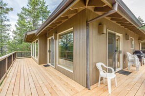 A wooden deck with a covered area, large windows, and outdoor seating. - White Elm 30 (Bend)