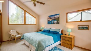 A bedroom with a large bed, a chair, a nightstand, and a ceiling fan. - Red Alder 3 (Bend)