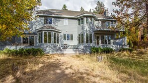 A large, two-story house with a covered porch and a driveway leading to the entrance. - Siskin 12 (Bend)