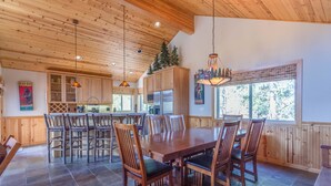 A spacious kitchen with wooden cabinets, a large dining table, and chairs. - Tokatee 30 (Bend)