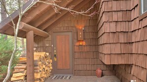 A wooden cabin with a door, a stack of firewood, and a number '9' sign.
