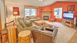 A living room with a fireplace, a television, and a sofa set. - Juniper 18 (Bend)