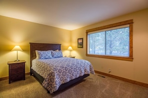 A bedroom with a bed, two bedside tables, a window with blinds, and a carpeted floor. - Tan Oak 38 (Bend)
