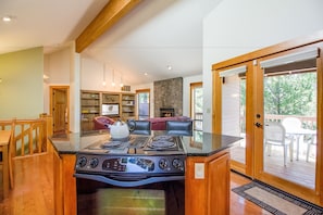 Enjoy cooking in this well-equipped kitchen with a central island, stovetop, and oven, plus a seating area with a sofa and chairs.