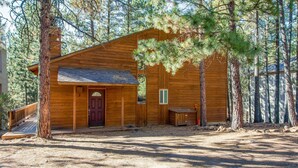 Une cabane en bois avec un porche à l’avant, une porte et une petite fenêtre.
