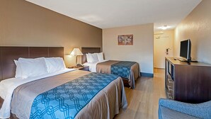 Een hotelkamer met twee bedden, een bureau, een televisie en een stoel.