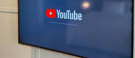 Un televisor de pantalla plana montado en la pared que muestra el logotipo de YouTube.