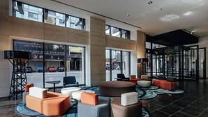 A modern lobby with seating areas, large windows, and a view of the street. - Greet Inn (Kaohsiung)