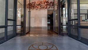 A modern building entrance with glass doors, a patterned floor, and a decorative ceiling. - Greet Inn (Kaohsiung)
