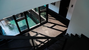A view from a high floor of a building with a pool visible through large windows.