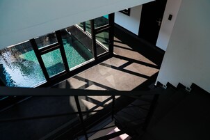 A view from a high floor of a building with a pool visible through large windows.