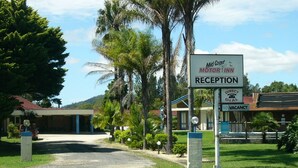Zona de recepción de un hotel con un cartel que indica recepción directa y habitaciones agotadas.
