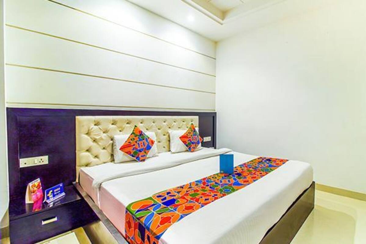 Une chambre d’hôtel comprenant un lit, une table de chevet et un meuble mural équipé d’une prise de courant.