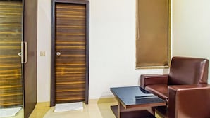 A room with a brown leather chair, a small table, and two doors with a striped pattern.