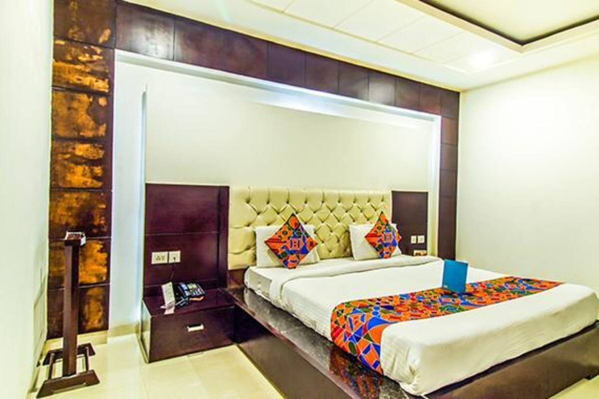 Une chambre d’hôtel moderne avec un grand lit, une table de chevet et une armoire intégrée.