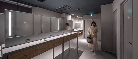A modern bathroom with a long vanity, multiple mirrors, and a clean, minimalist design.