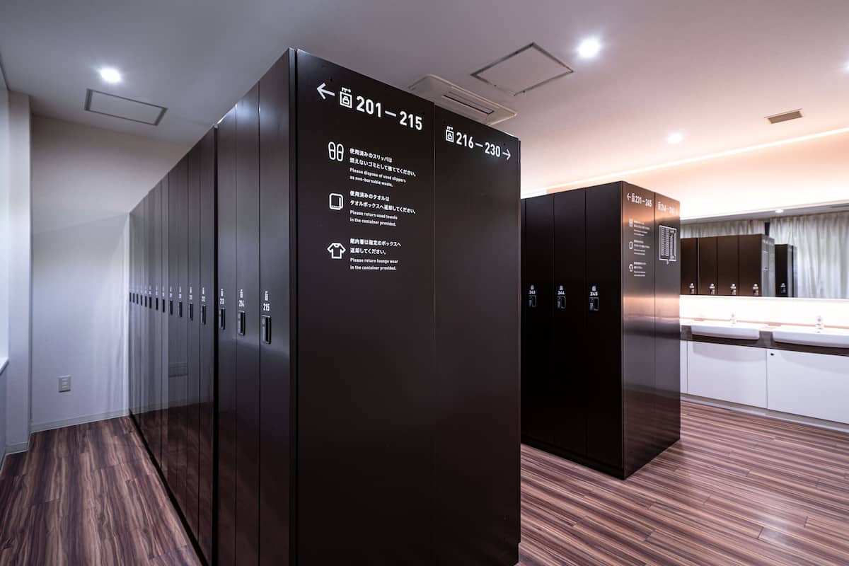 A modern elevator with directional signs indicating floors 201-215 and 216-230.
