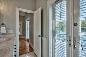 A bathroom with a sink, towel rack, and a door leading to a hallway. - Magnolia Cottages 163 Patina 3 Bedroom Holiday Home By Coastal Dreamin (Panama City Beach)