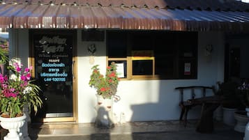 En lille bygning med et skilt der siger "White Elephant Resort" og et kontaktnummer.