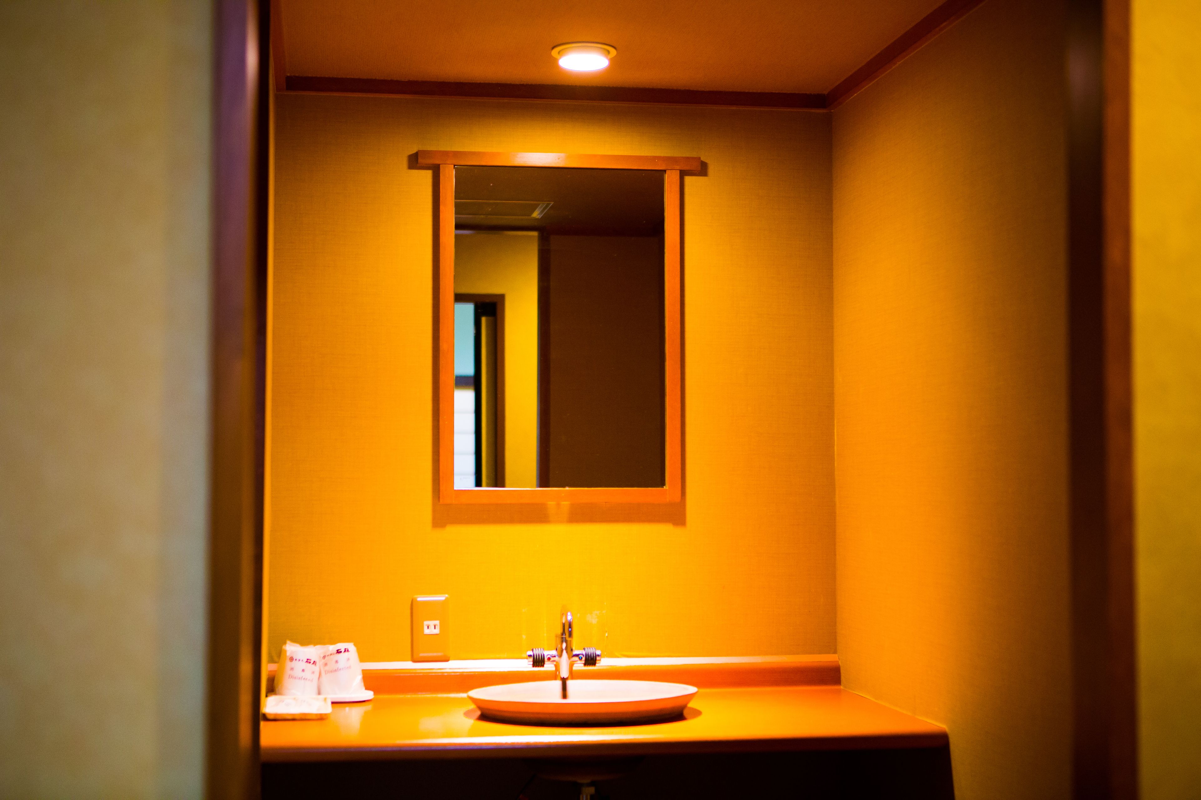 A bathroom with a sink, mirror, and a light fixture above the mirror.