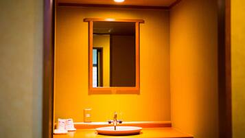A bathroom with a sink, mirror, and a light fixture above the mirror.