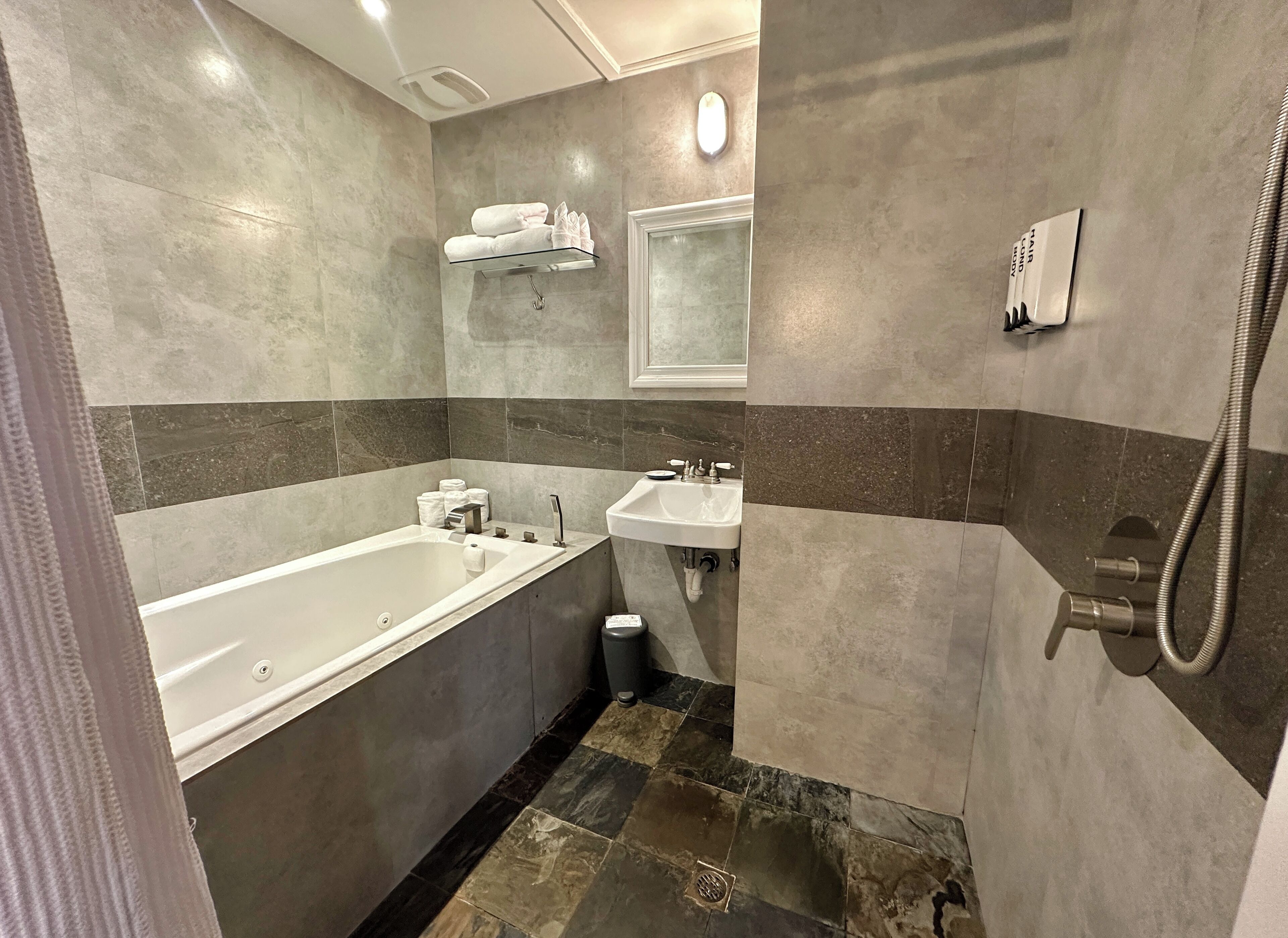 Un baño moderno con bañera, lavamanos y ducha.