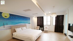 A bedroom with a large bed, a night sky mural, two chairs, a TV, and a window with curtains.