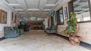 Eine Lobby mit Marmorboden, Sitzbereichen und einer Rezeption.