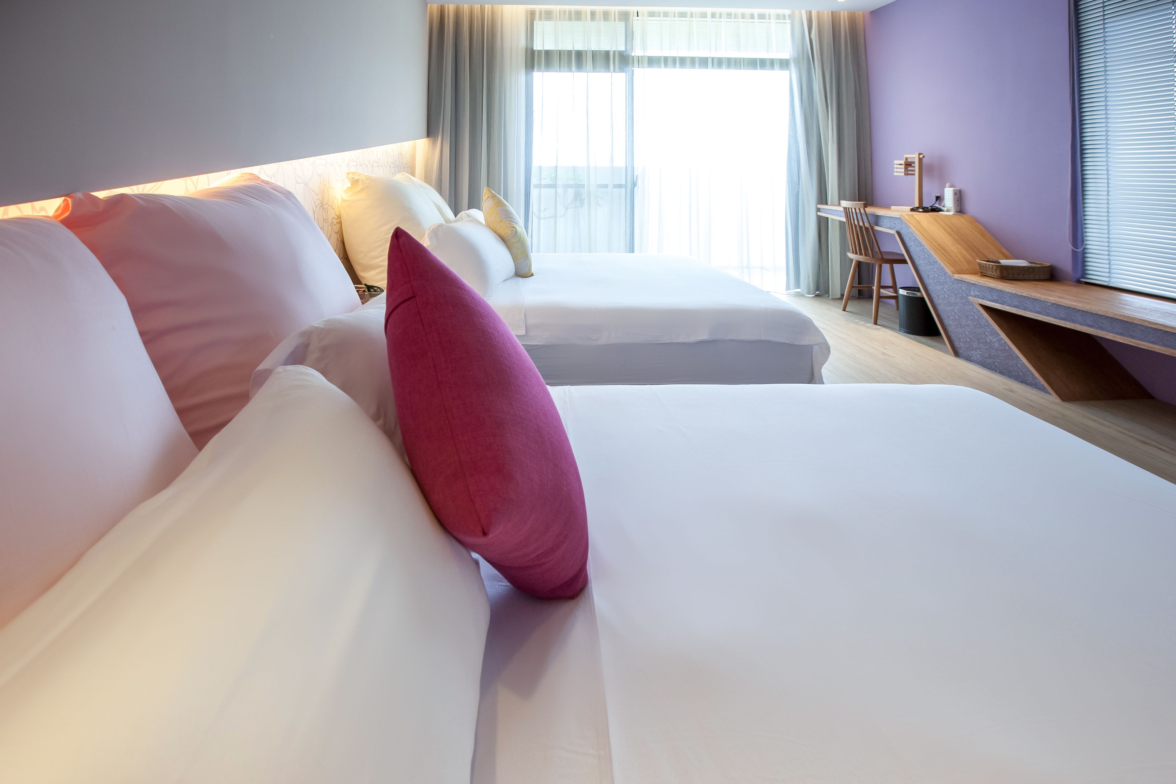 Ein Hotelzimmer mit zwei Betten, einem Schreibtisch und Blick ins Freie.