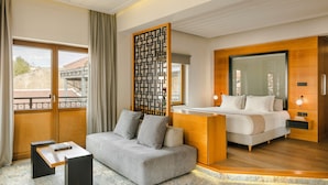 Een moderne hotelkamer met een sofa, een bed, een bureau en een groot raam.