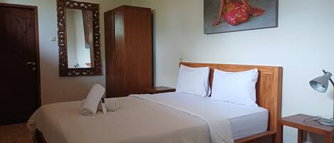 A neatly made bed with white linens, a wooden headboard, and two bedside tables with lamps.